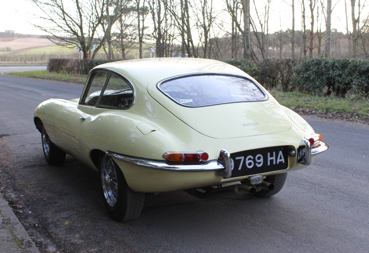 Rear three-quarter view of a Primrose 1963 Series 1 3.8 fixed-head coupe registered 9769 HA, parked on a country road